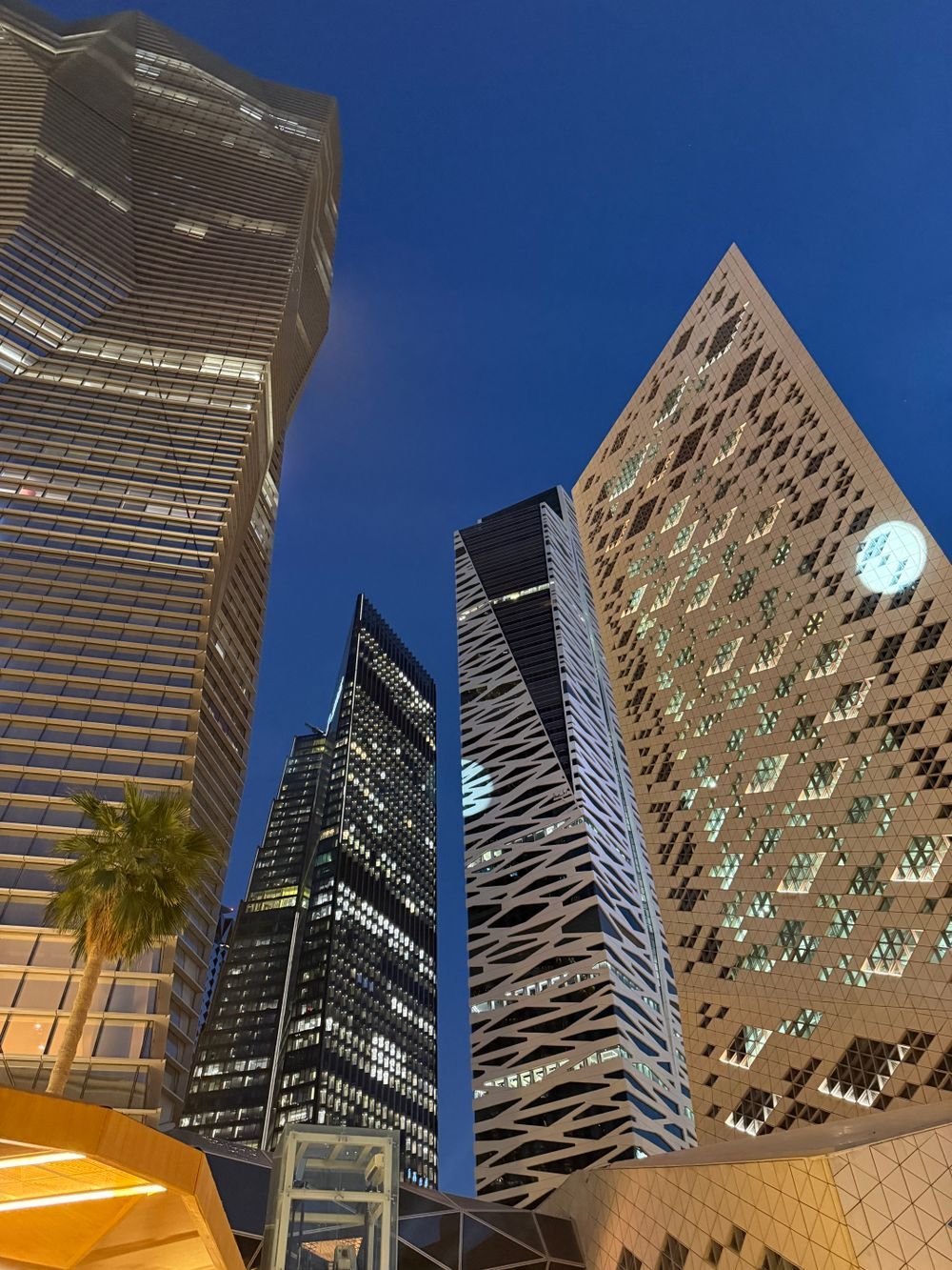 Contemporary skyscrapers lit up at night in Riyadh's financial district
